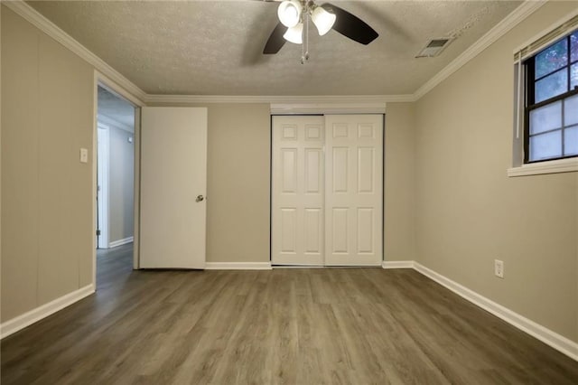 unfurnished bedroom with ornamental molding, a textured ceiling, ceiling fan, hardwood / wood-style flooring, and a closet