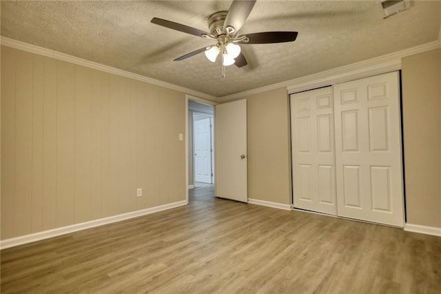 unfurnished bedroom featuring ceiling fan, light hardwood / wood-style flooring, a textured ceiling, and ornamental molding