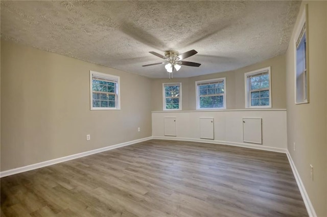 unfurnished room with wood-type flooring and a textured ceiling