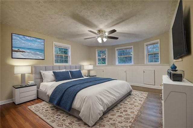 bedroom featuring a textured ceiling, dark hardwood / wood-style flooring, and ceiling fan