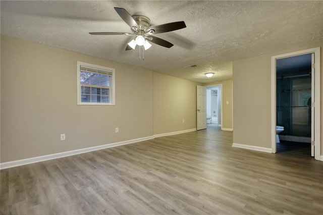 spare room with a textured ceiling, hardwood / wood-style flooring, and ceiling fan