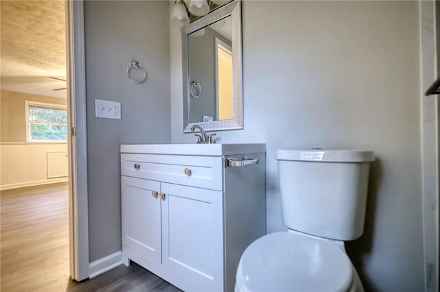 bathroom featuring hardwood / wood-style floors, vanity, a textured ceiling, and toilet