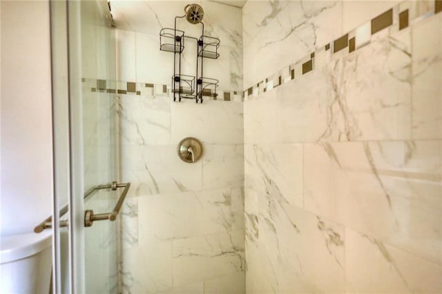 bathroom featuring toilet and tiled shower