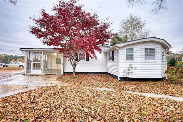 rear view of property featuring a sunroom