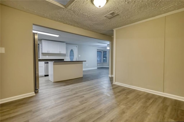 kitchen with stainless steel appliances, white cabinetry, ceiling fan, and wood-type flooring