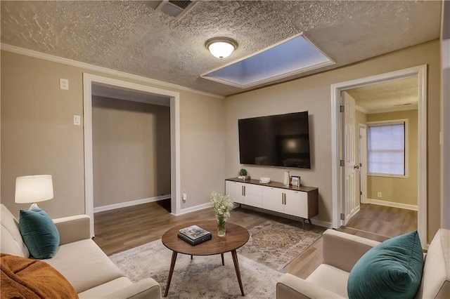 living room with a textured ceiling, hardwood / wood-style flooring, and ornamental molding