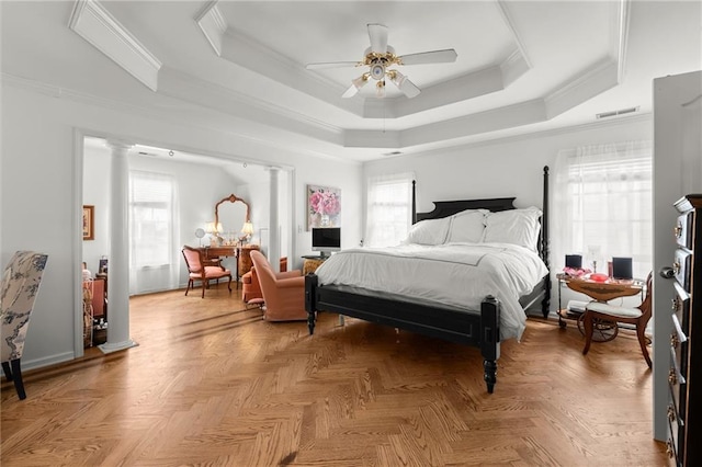 bedroom with visible vents, a raised ceiling, a ceiling fan, crown molding, and ornate columns