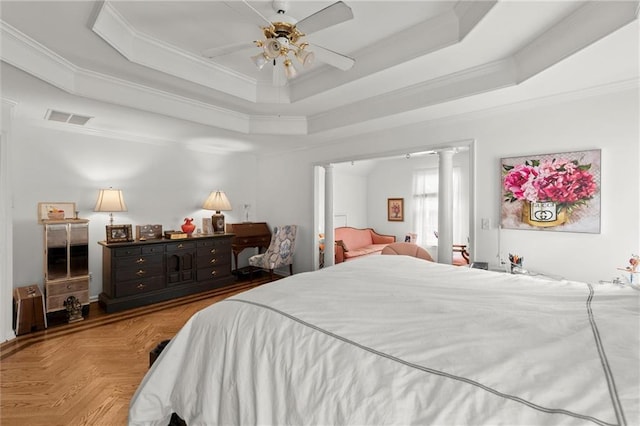 bedroom featuring ornamental molding, a tray ceiling, visible vents, and ornate columns