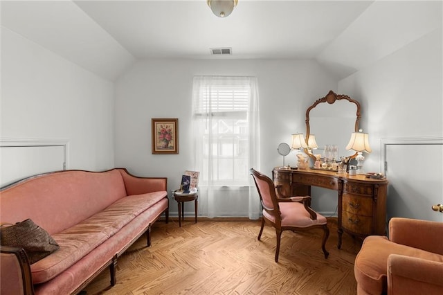 sitting room featuring vaulted ceiling, visible vents, and baseboards