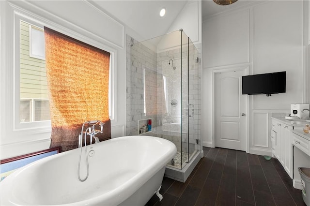 bathroom featuring a freestanding tub, plenty of natural light, a decorative wall, and a shower stall