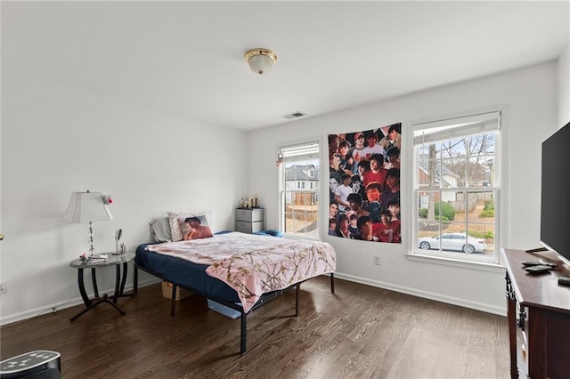 bedroom featuring baseboards, visible vents, and dark wood finished floors