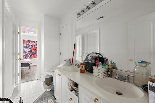 ensuite bathroom with double vanity, visible vents, a sink, and tile patterned floors