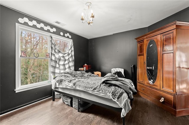 bedroom featuring a chandelier, wood finished floors, and visible vents