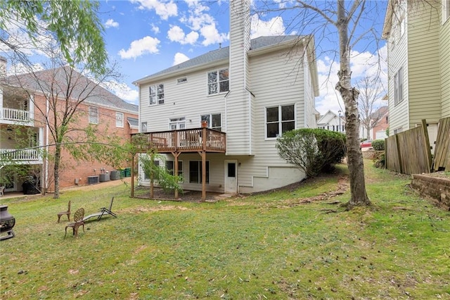 rear view of house with a deck, a yard, a chimney, and central air condition unit