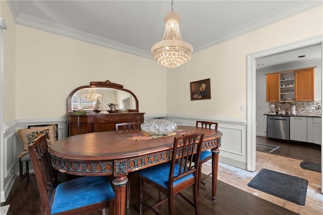 dining space with ornamental molding, wood finished floors, and wainscoting