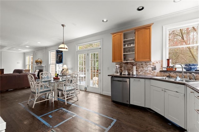 kitchen with dark wood-type flooring, a sink, ornamental molding, stainless steel dishwasher, and decorative backsplash