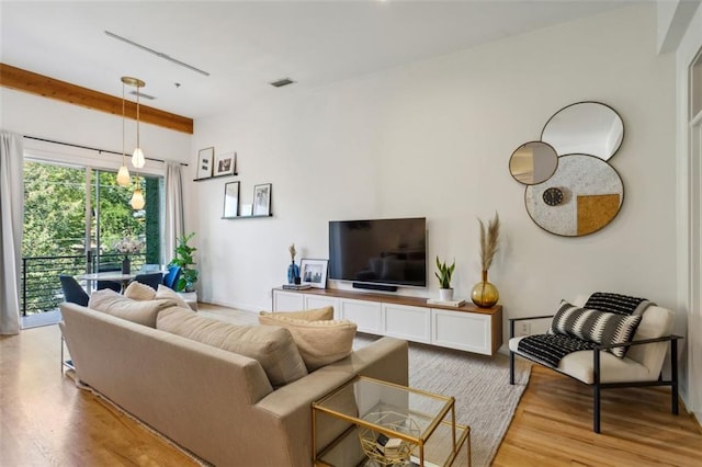 living area featuring light wood-type flooring and visible vents