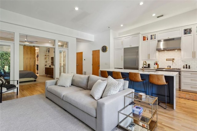 living area with recessed lighting, visible vents, light wood-style floors, and a ceiling fan