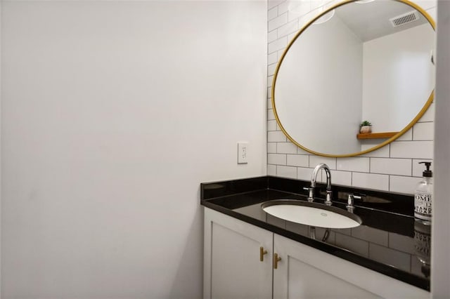 bathroom with vanity, visible vents, and tasteful backsplash