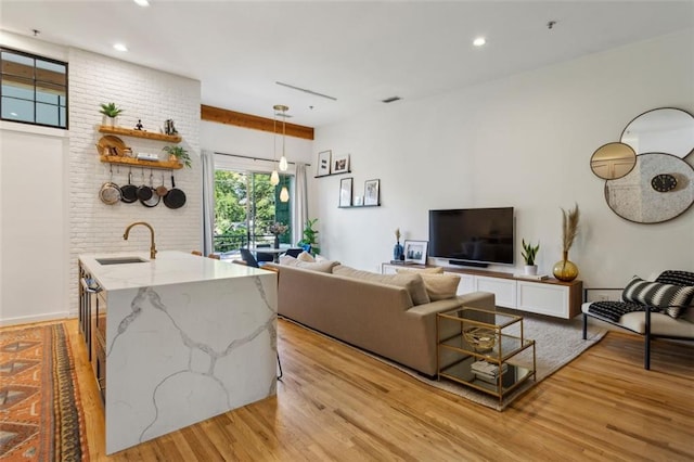 living area featuring light wood-style flooring, recessed lighting, and visible vents