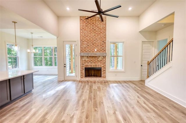 460 Ridge Point Dr, Monticello, GA 31064 - unfurnished living room with a ceiling fan, plenty of natural light, baseboards, a high ceiling, and light wood finished floors