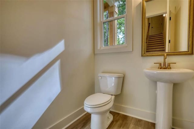 460 Ridge Point Dr, Monticello, GA 31064 - half bath featuring toilet, wood finished floors, baseboards, and a sink