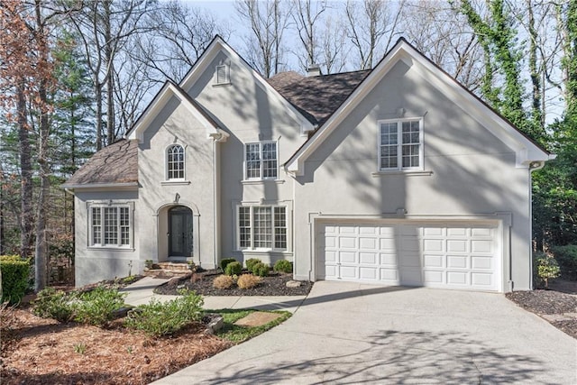 view of front of property with a garage, concrete driveway, and stucco siding