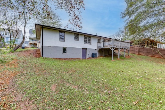 back of house featuring central air condition unit, a deck, and a lawn