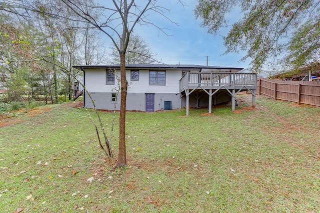 back of house featuring central AC, a deck, and a lawn