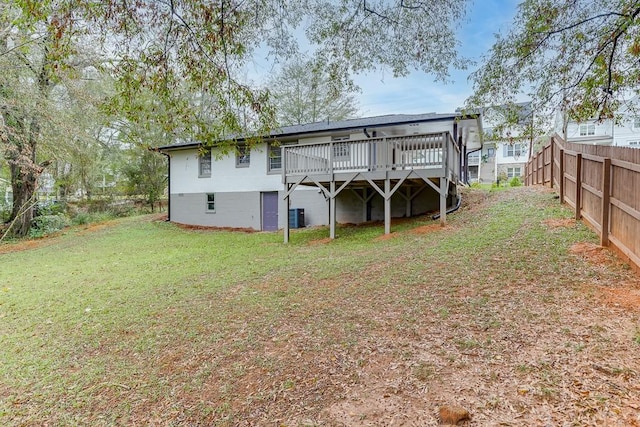 back of property featuring a lawn, cooling unit, and a deck