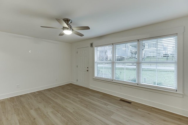 spare room featuring light wood-type flooring, plenty of natural light, and ceiling fan