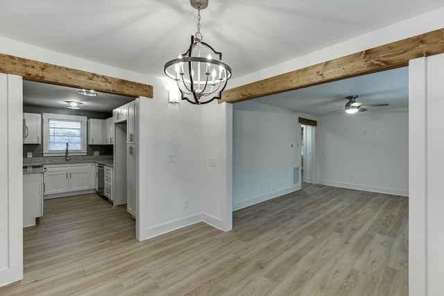 kitchen featuring ceiling fan with notable chandelier, sink, beamed ceiling, light hardwood / wood-style floors, and white cabinetry