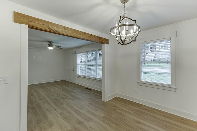 spare room with wood-type flooring and ceiling fan with notable chandelier