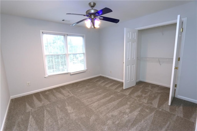 unfurnished bedroom featuring ceiling fan, dark carpet, and a closet