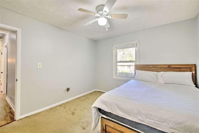 carpeted bedroom with ceiling fan and a textured ceiling