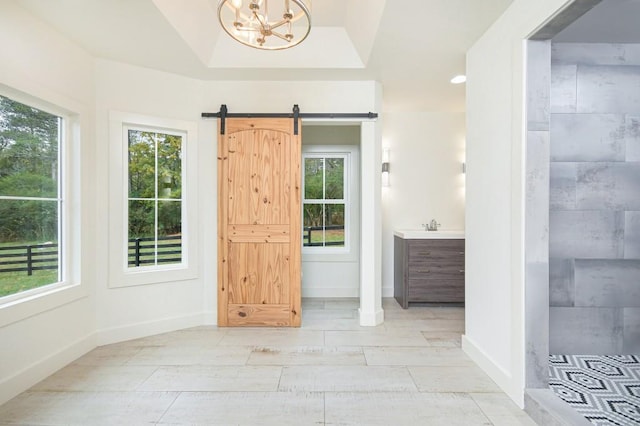 doorway featuring vaulted ceiling, a chandelier, sink, and a barn door