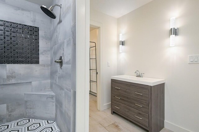 bathroom featuring tile patterned flooring, vanity, and tiled shower