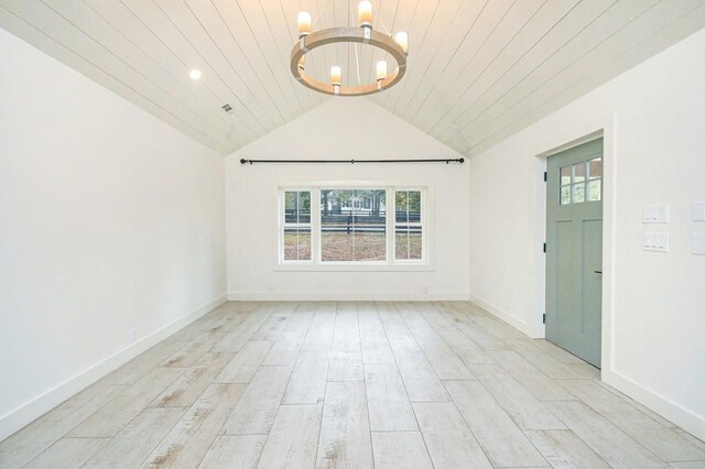 unfurnished room featuring vaulted ceiling, an inviting chandelier, light hardwood / wood-style flooring, and wood ceiling