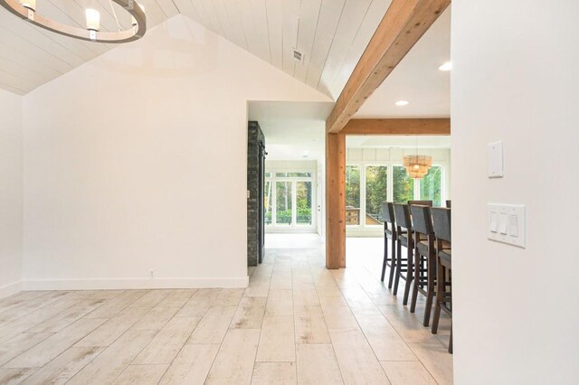 interior space featuring vaulted ceiling with beams, light hardwood / wood-style flooring, and a notable chandelier