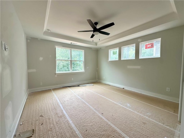 7040 Manchester Dr, Flowery Branch, GA 30542 - unfurnished room featuring a tray ceiling, healthy amount of natural light, ceiling fan, and baseboards