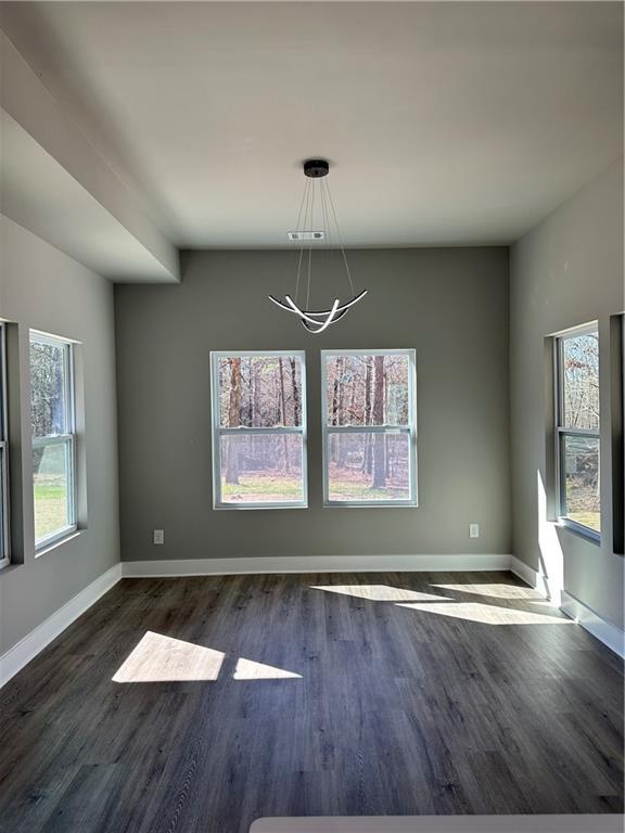 unfurnished dining area featuring dark hardwood / wood-style flooring and a chandelier