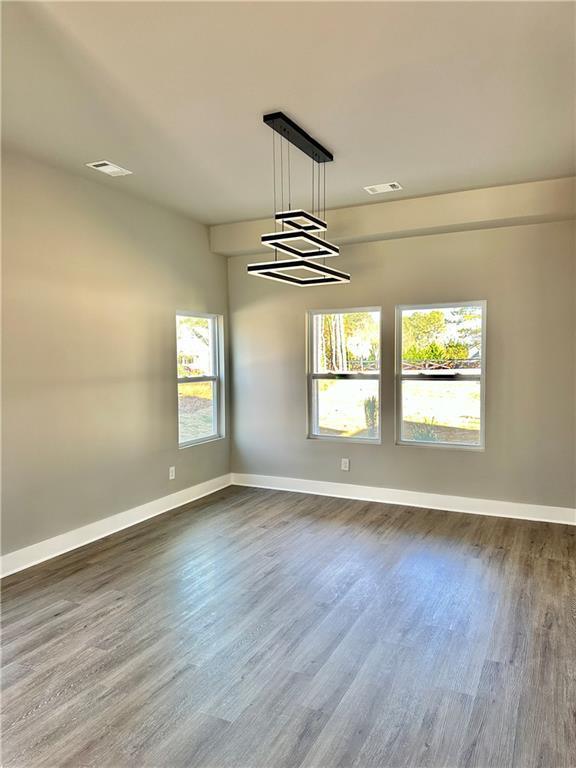 unfurnished room with dark hardwood / wood-style flooring