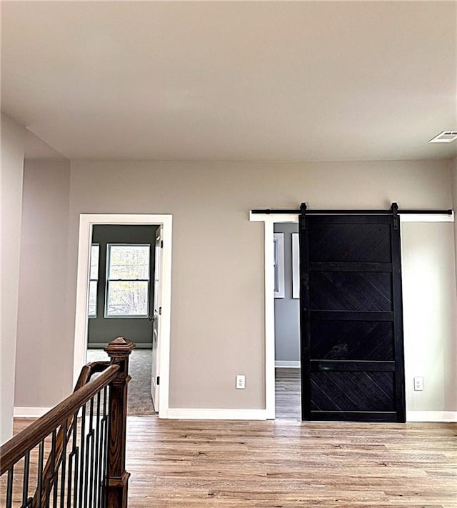 interior space with a barn door and light hardwood / wood-style floors