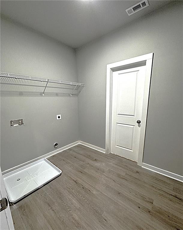 laundry area featuring electric dryer hookup and hardwood / wood-style flooring