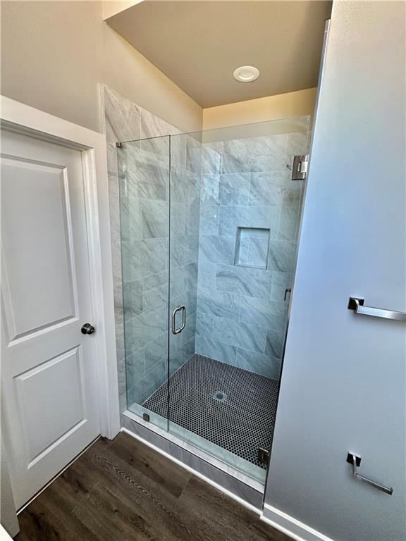 bathroom featuring hardwood / wood-style flooring and an enclosed shower