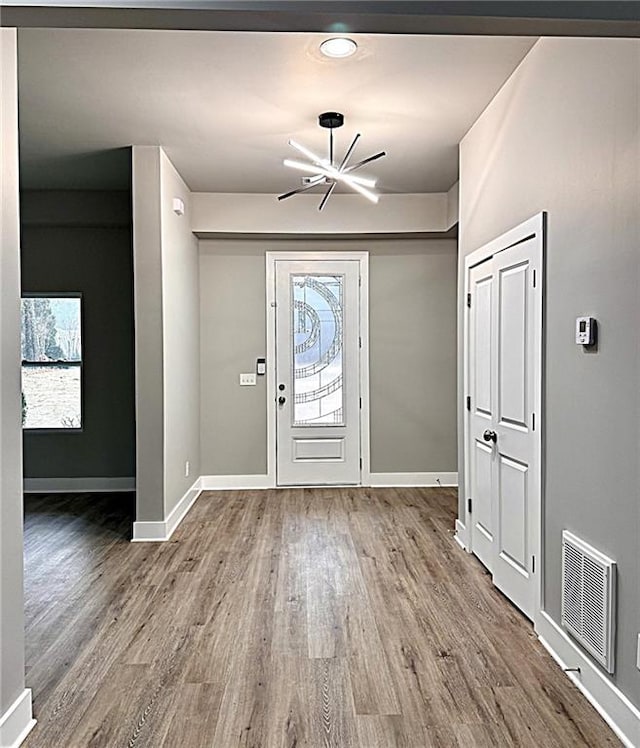 entrance foyer with hardwood / wood-style floors and a chandelier