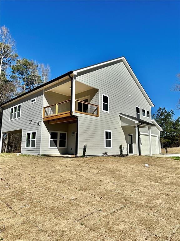 back of property featuring a garage and a balcony