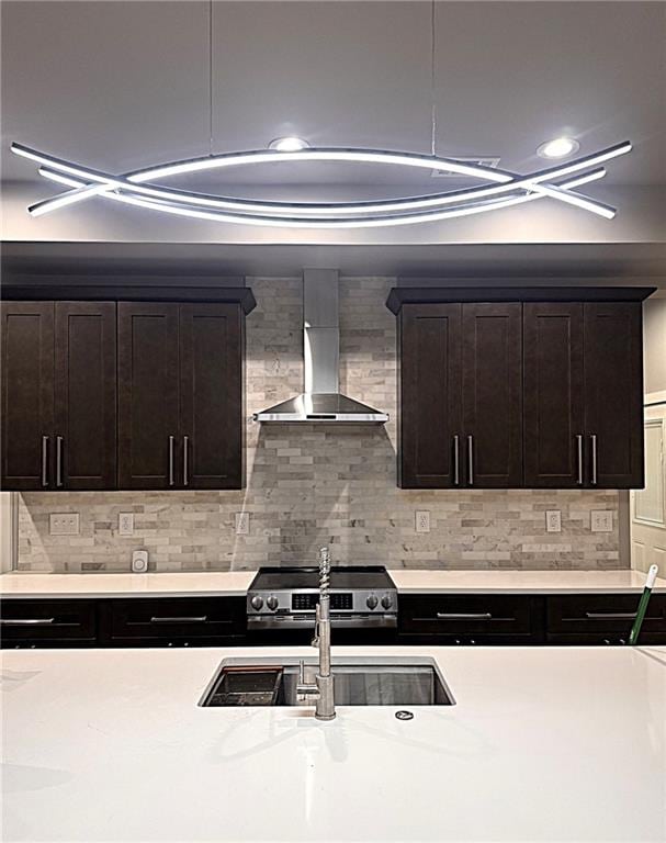 kitchen featuring stainless steel electric range oven, decorative backsplash, and wall chimney range hood