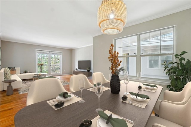 dining area featuring wood-type flooring and crown molding