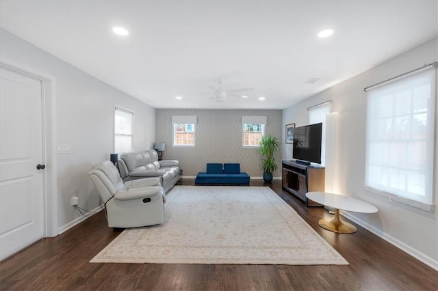 living room featuring ceiling fan and dark hardwood / wood-style flooring